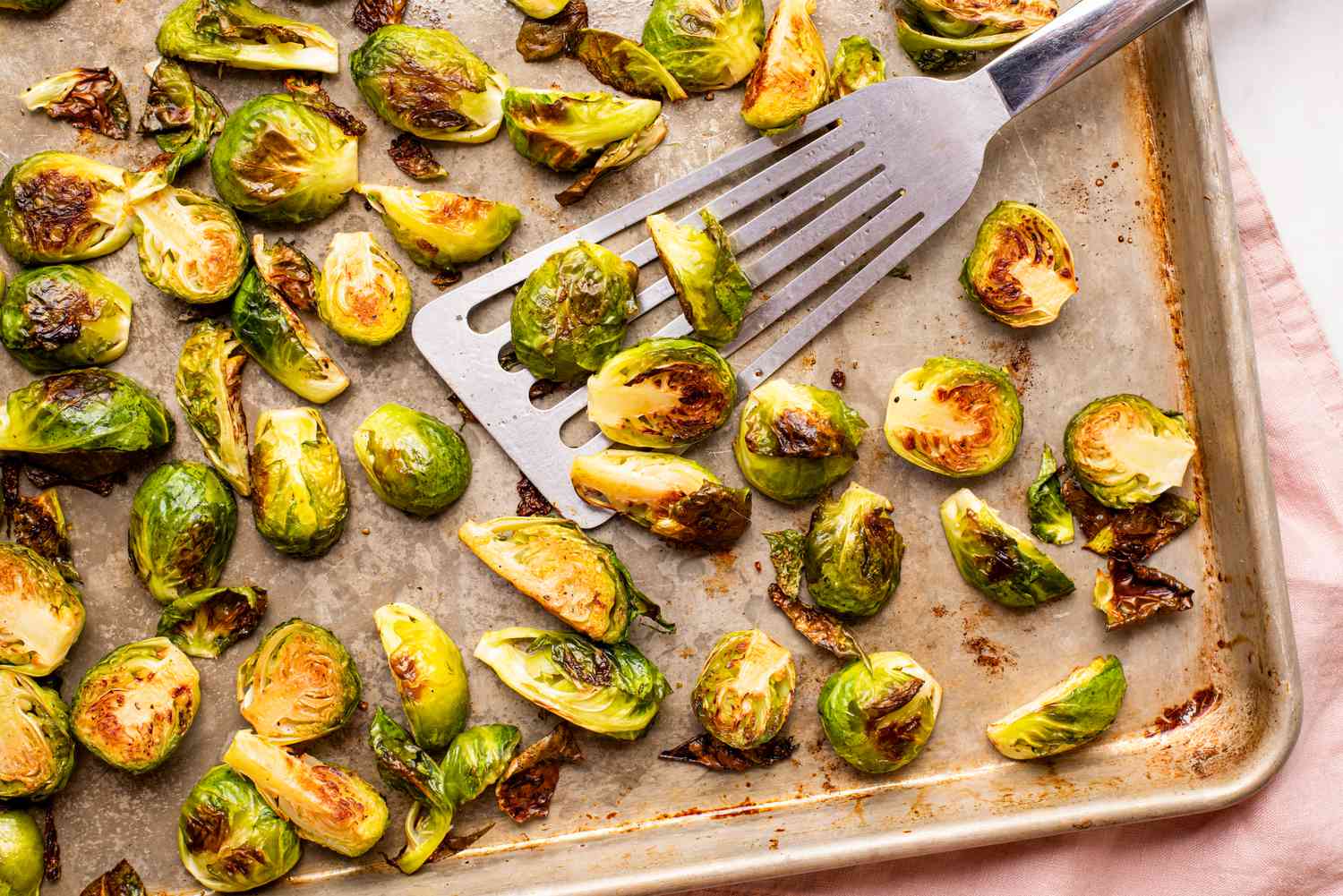 Roasted brussels sprout halves on a baking sheet