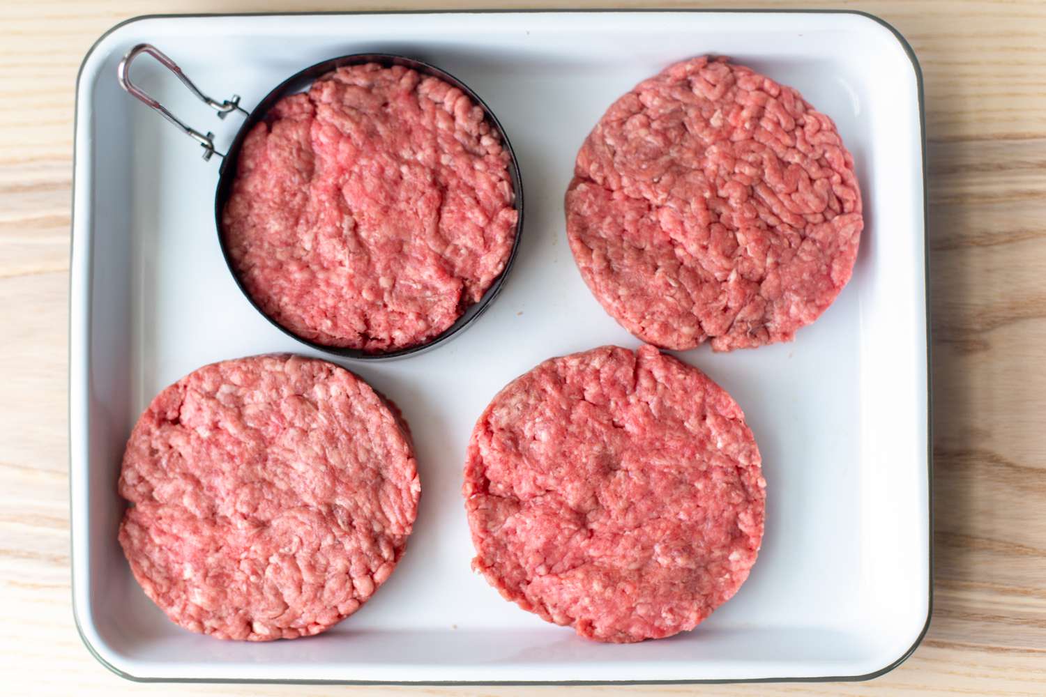 Ground Beef Shaped Into 4 Circular Burger Patties Using a Burger Mold on a Platter for Burger Salad Recipe