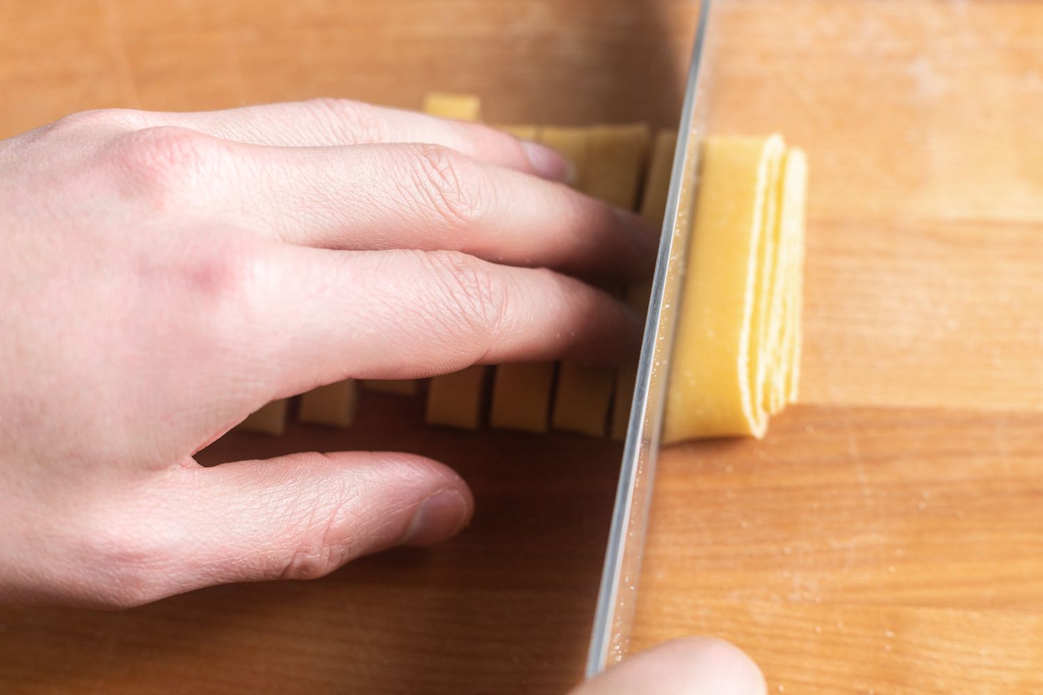 Tagliatelle Dough Cut Into Strips Using a Knife After Flattened Dough Was Carefully Folded on Itself
