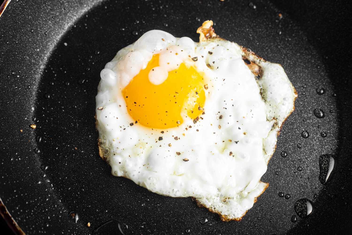 An egg frying in a small nonstick skillet