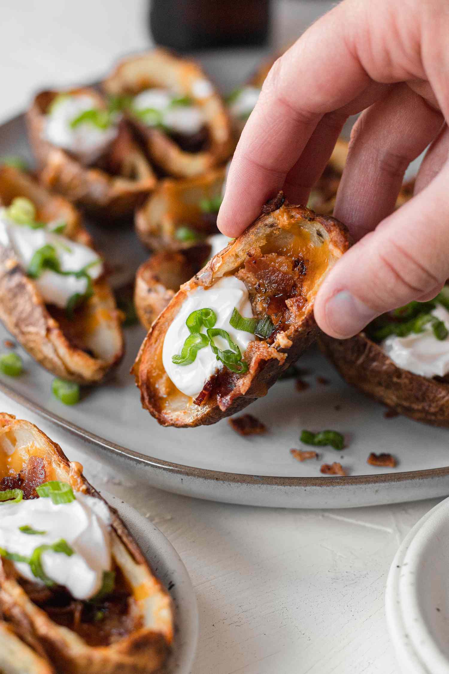 Picking up potato skins off a platter.