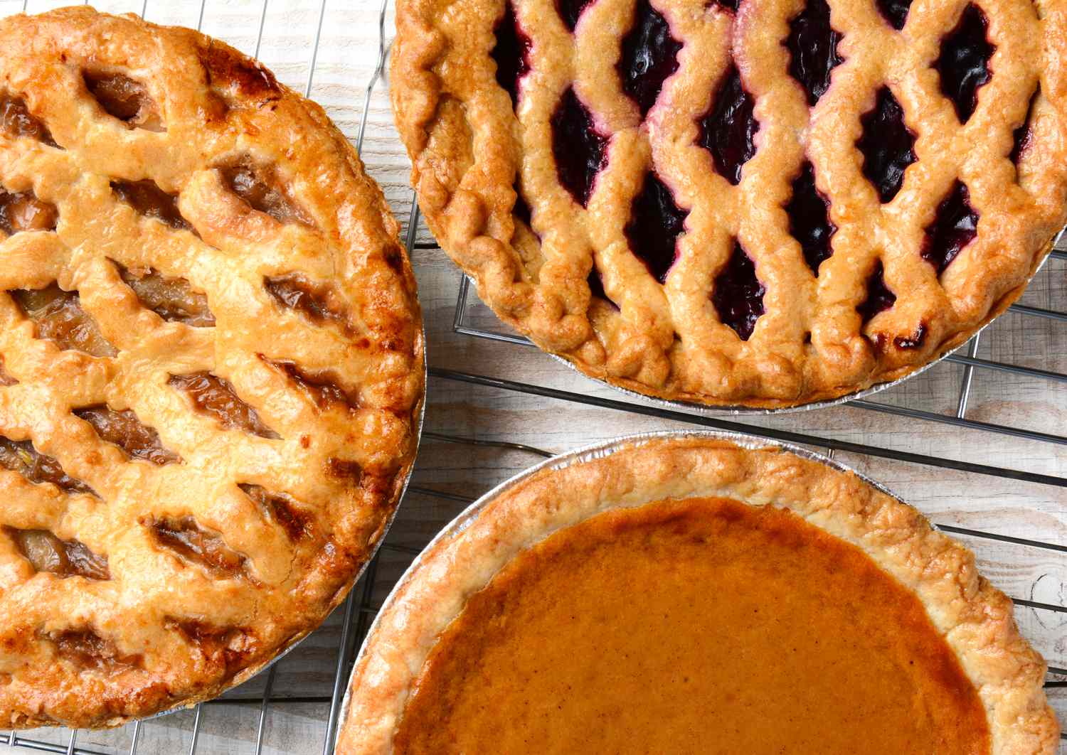 Three assorted pies one with a pumpkin filling and two with lattice crusts