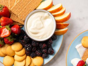 Plate of cheesecake dip with fruits graham crackers and cookies