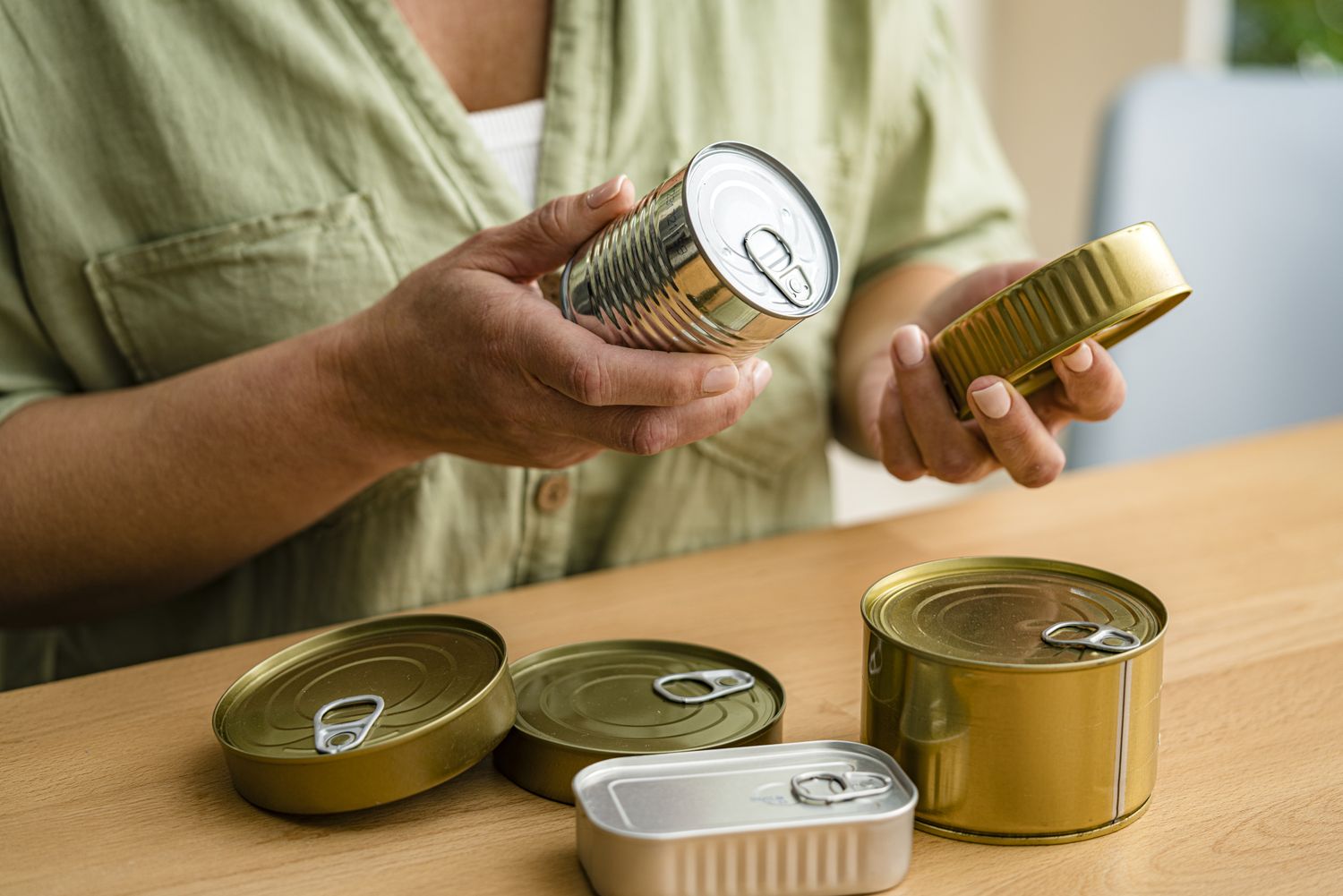 Person examining canned foods on a table