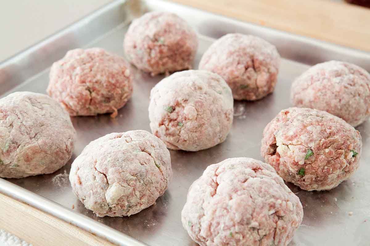 Coat homemade italian meatballs in flour
