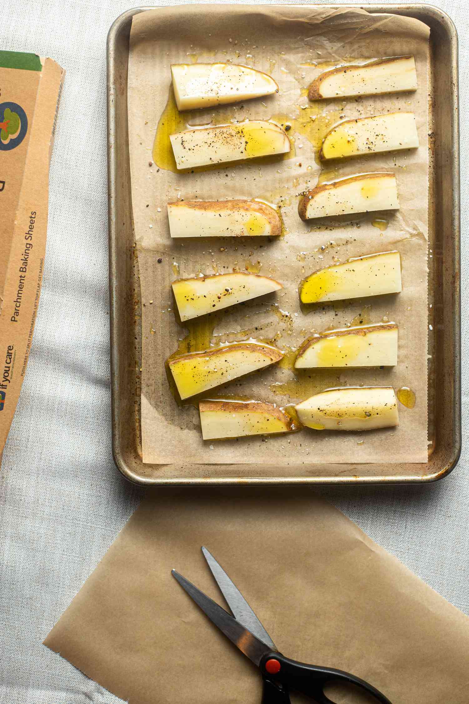 Potatoes on parchment paper lined half sheet pan