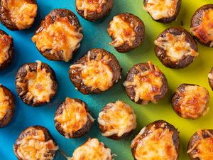 Baked stuffed mushrooms topped with melted cheese displayed on a colorful background
