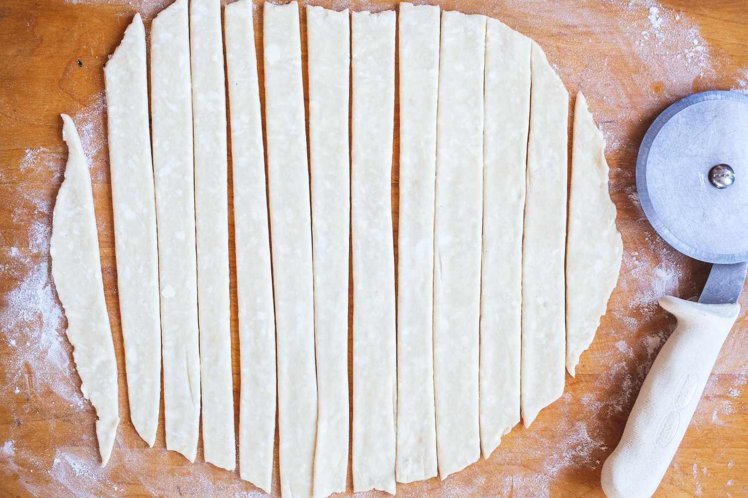 Cutting a pie crust into strips to show how to make a lattice crust.