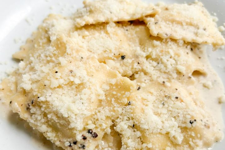 Cacio e pepe pasta dish garnished with grated cheese and black pepper