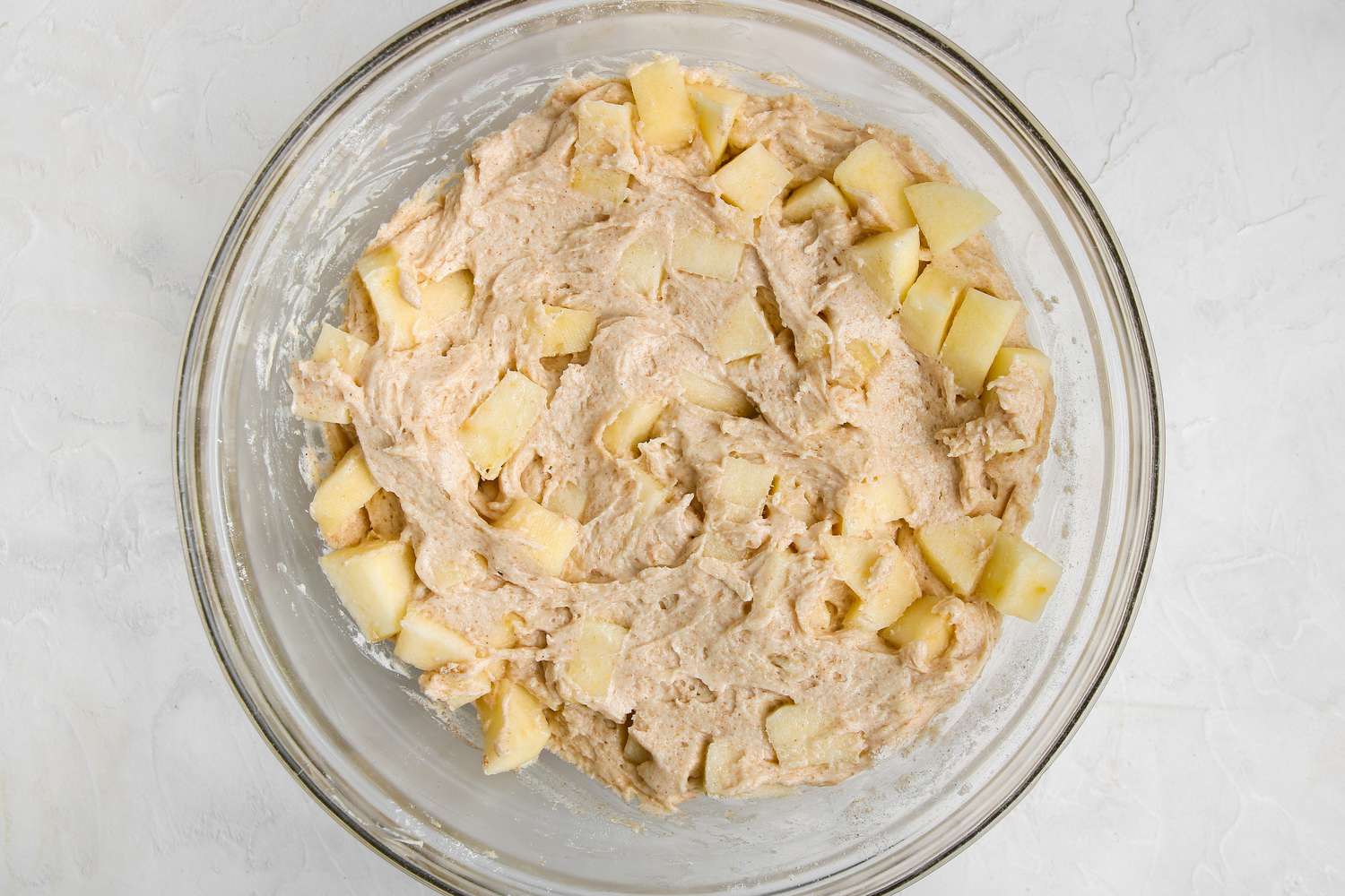 Chopped apples added to batter to make cinnamon streusel apple bread.