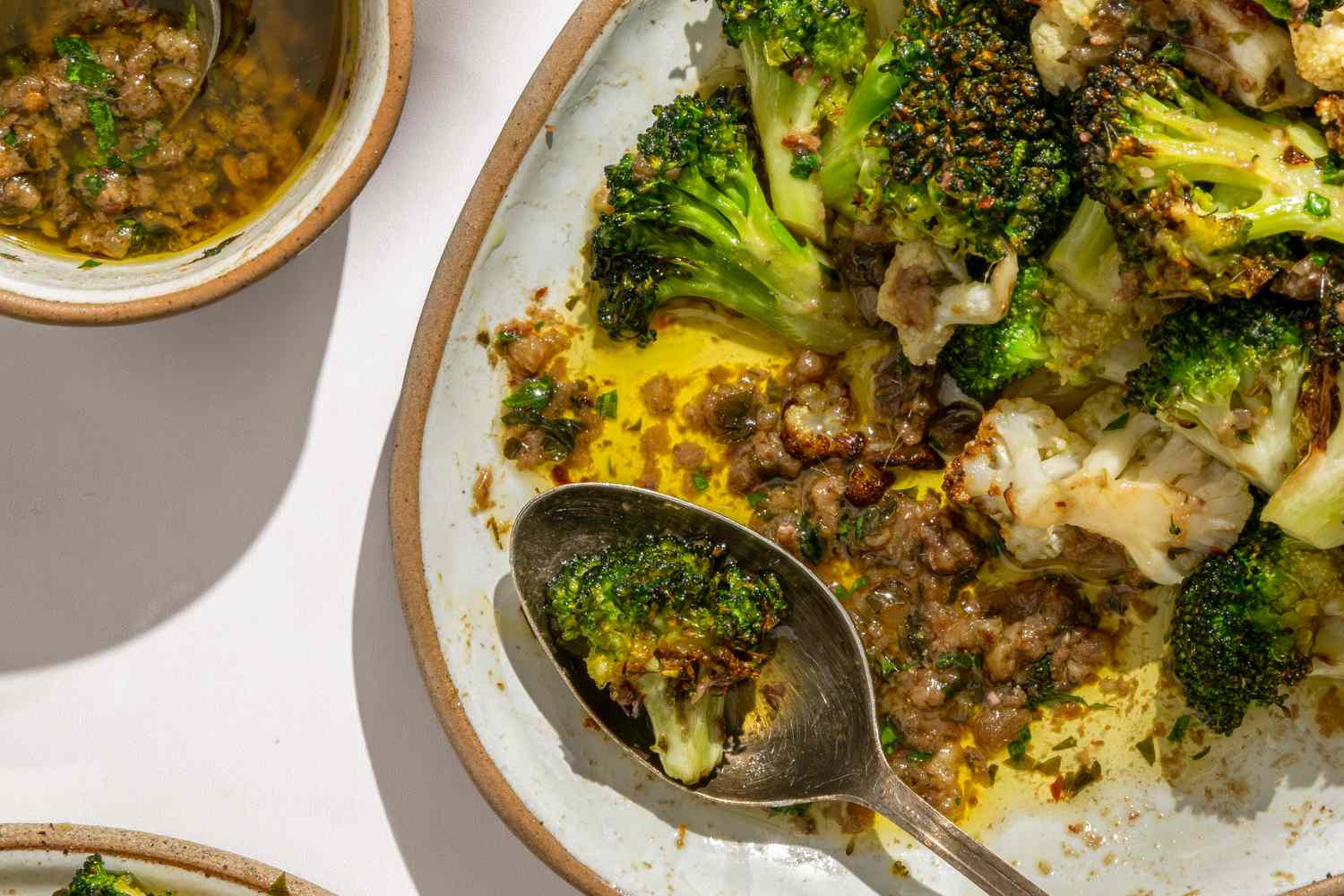 Overhead closeup shot of a plate with broccoli and cauliflower topped with bagna cauda