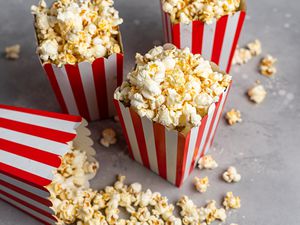 Red striped paper cartons overflowing with popcorn recipes