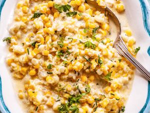 A serving spoon with homemade cream corn inside.