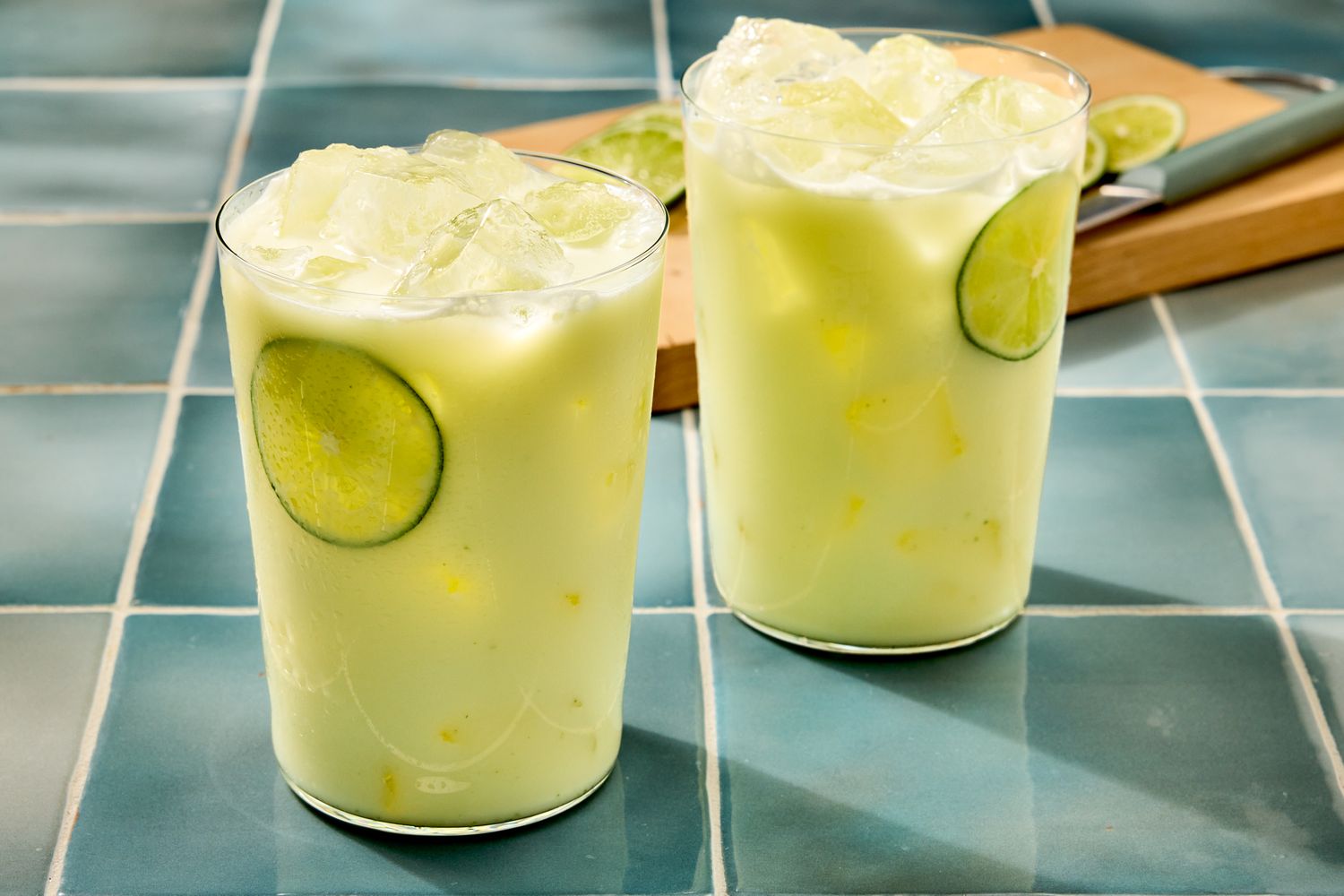 Two glasses of limonada on a tiled surface