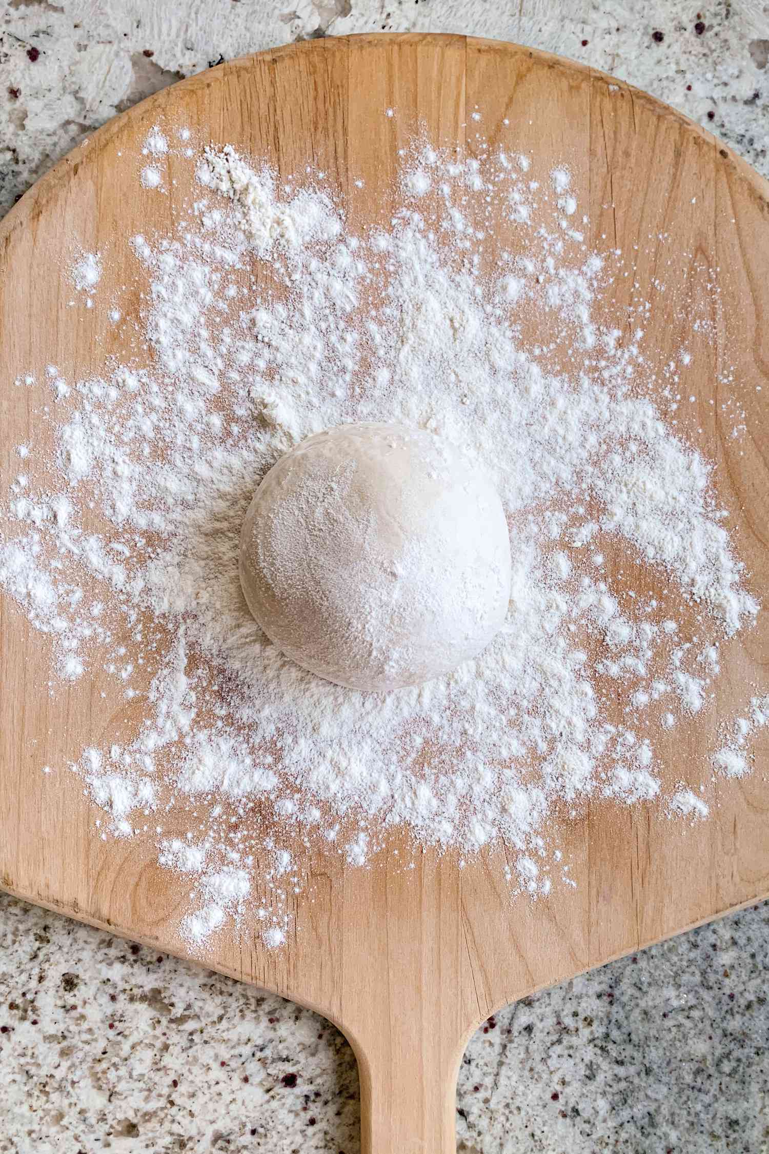 Pizza dough ball on a floured wood pizza peel