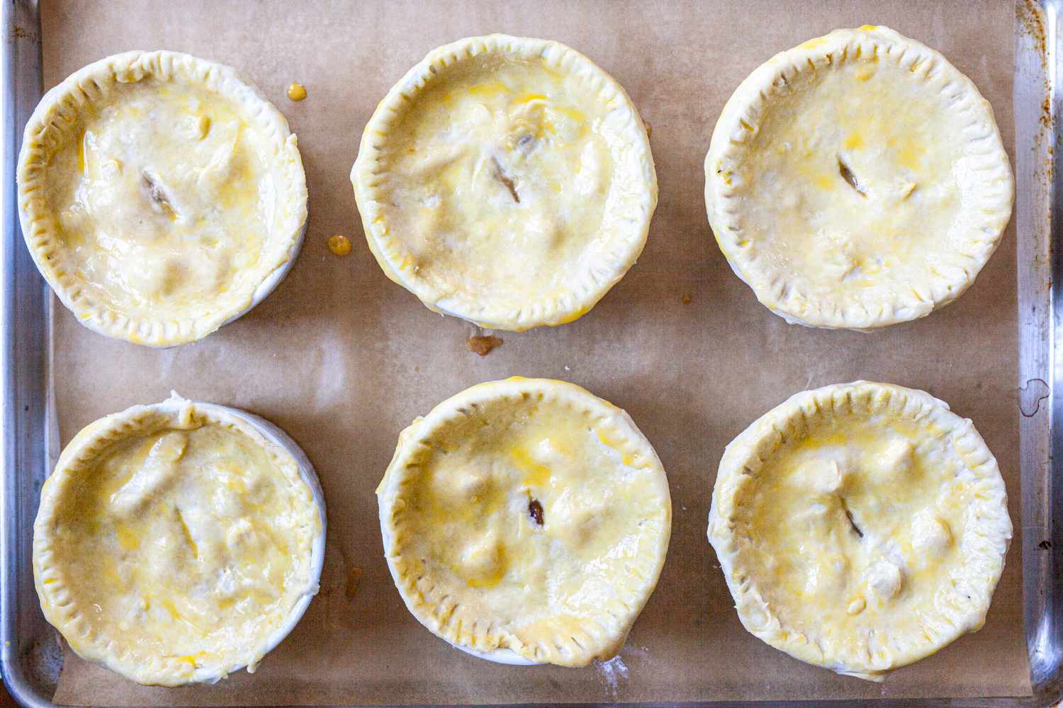 Individual turkey pot pies brushed with egg wash.