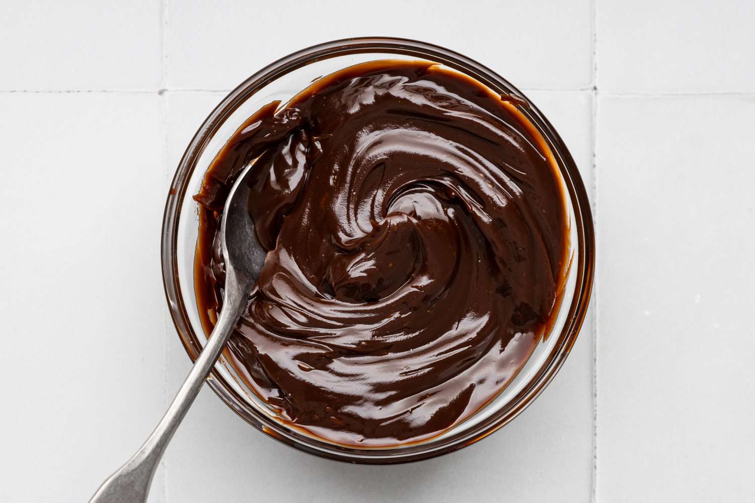 Bowl of Hot Fudge With a Spoon In It for Oreo Cookie Ice Cream Cake Recipe