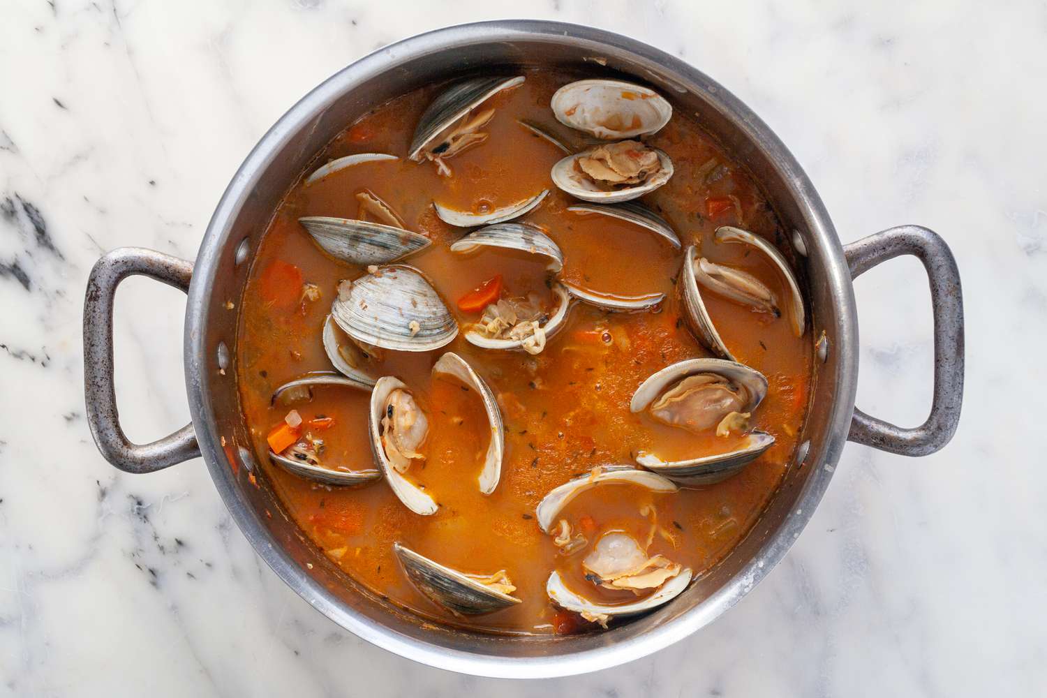 Manhattan Clam Chowder in a pot with cooked clams steamed open and ready to dig into