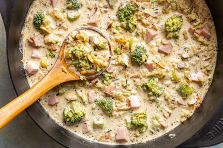Broccoli and wild rice soup in a pot with a wooden ladle