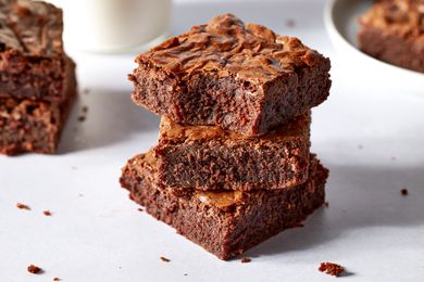 Side view of three brownies stacked on top of each other with a bite bitten from the brownie at the top