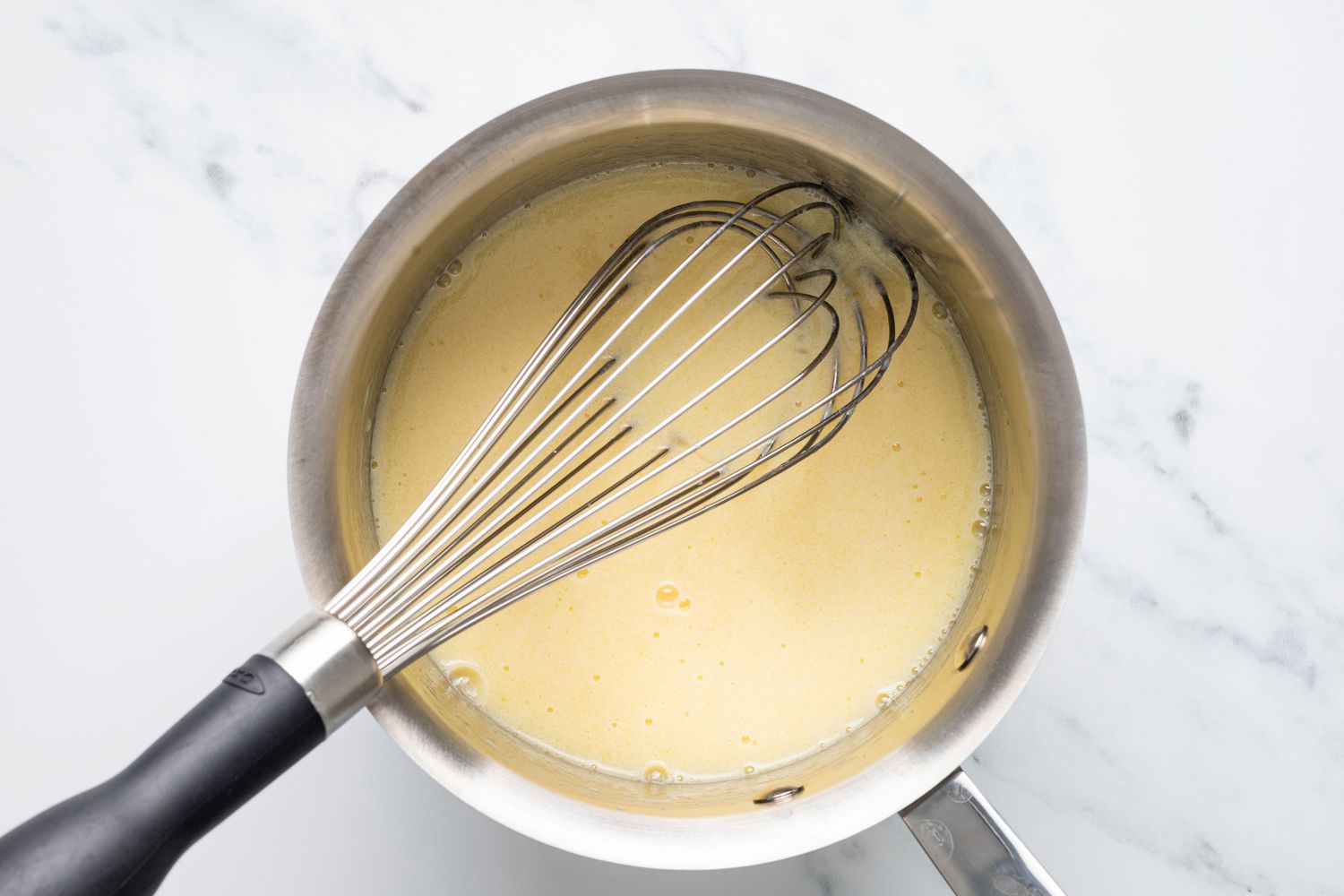 Liquid Ingredients in Pot with a Whisk for Pepperoni Rolls
