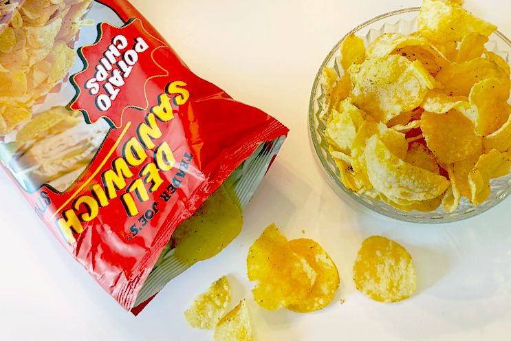 Bag of deli sandwich flavored potato chips next to a glass bowl filled with chips
