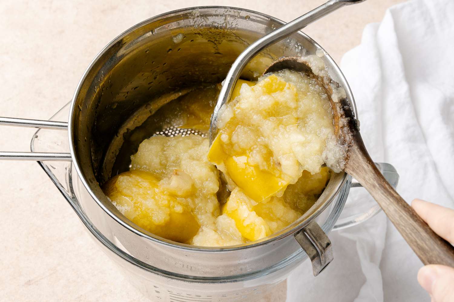 Cooked Apples Spooned into a Sieve for Apple Butter Recipe
