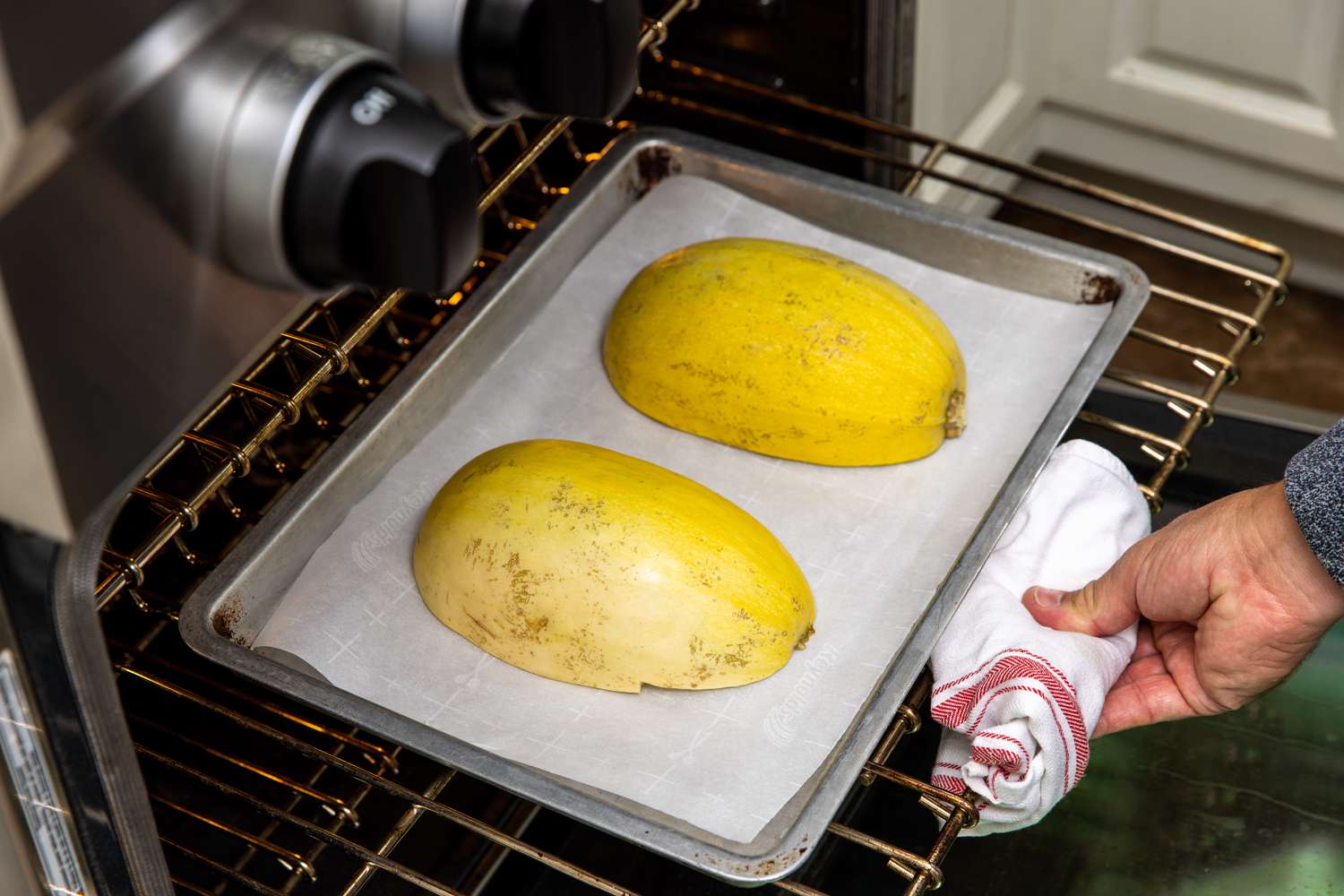Baking Pan Placed on Oven Rack and Rack Pushed into the Oven Using a Folded Kitchen Towel for Spaghetti Squash Soup with Italian Sausage