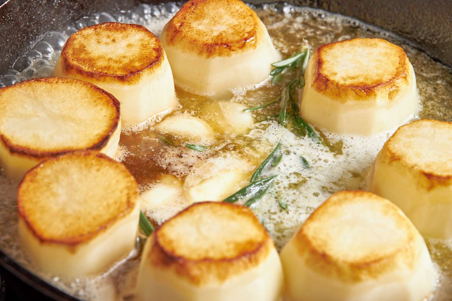 Garlic, rosemary sprig, and broth added skillet and cooked in the butter for fondant potatoes recipe