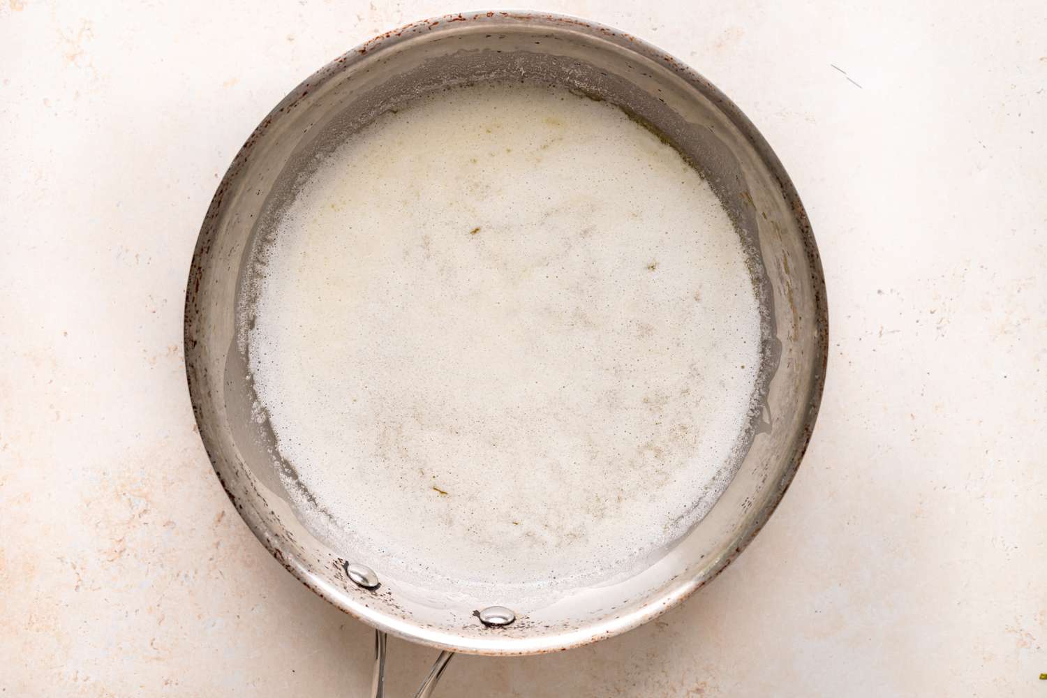 Melted butter foaming in a pot to make brown butter.