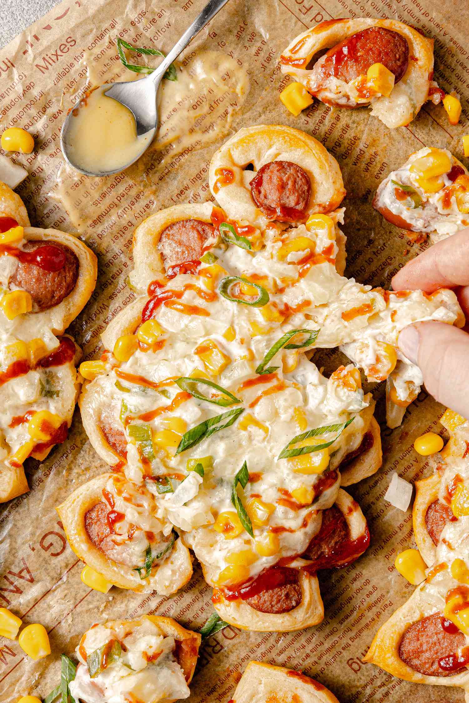 Pull-Apart Corn Cheese Pigs in a Blanket with a Piece Pulled Off Surrounded by More