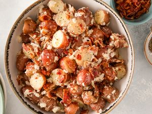 A bowl of potato salad topped with crumbled bacon