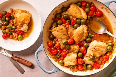 Overhead view of a blue dutch oven and small white bowl of tuscan-style chicken thighs recipe