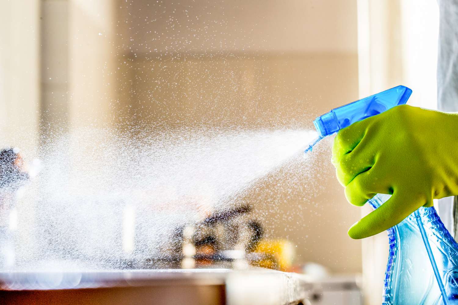 someone spraying the counters with a cleaning spray