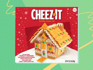 A holiday gingerbreadstyle house made of CheezIt crackers displayed on a product box for a holiday house kit
