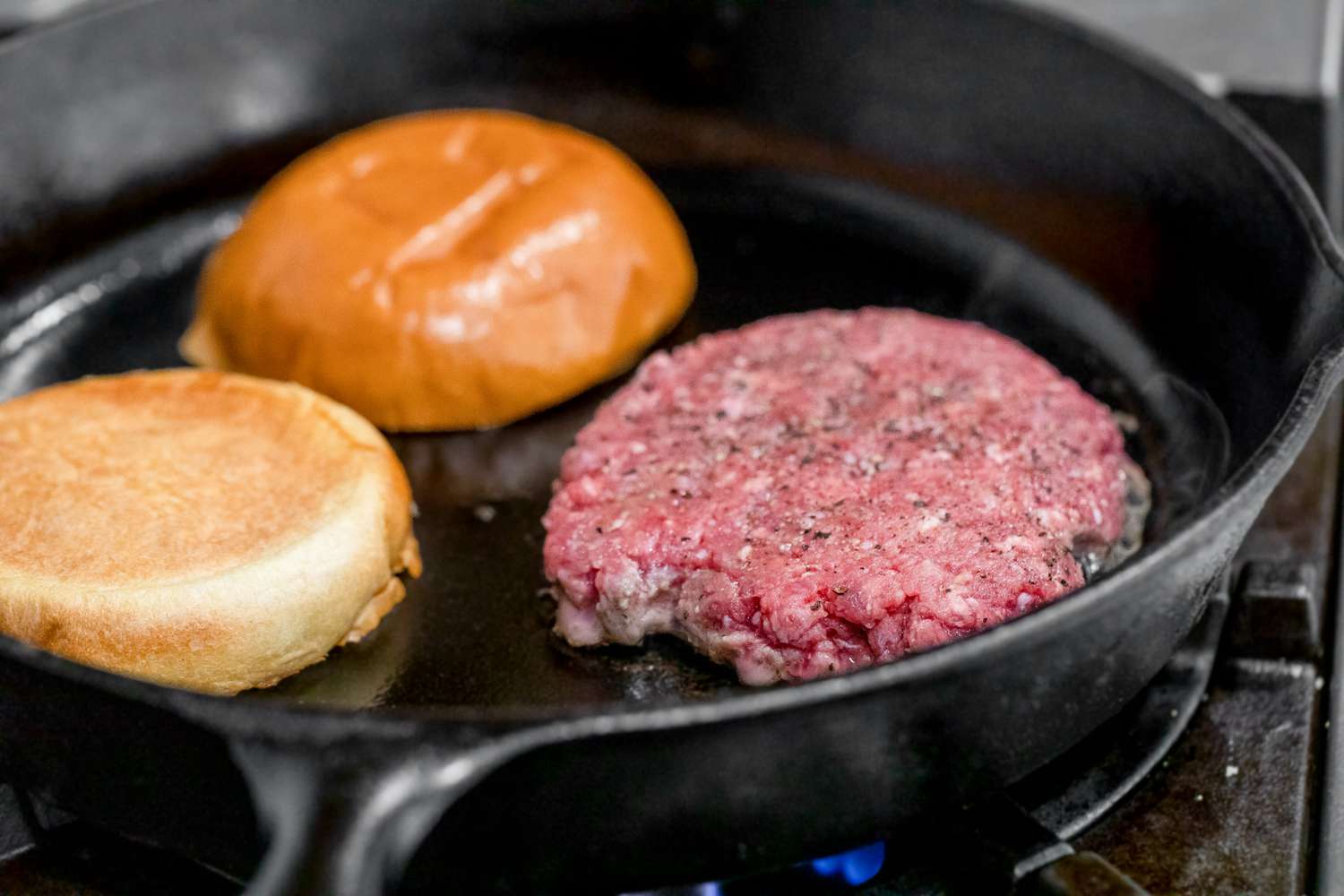 Burger Cooking in a Cast Iron Skillet with Burger Buns Toasting Next to It for Burgers on the Stove Recipe