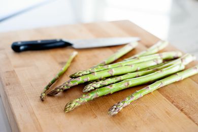 pile of asparagus on cutting board