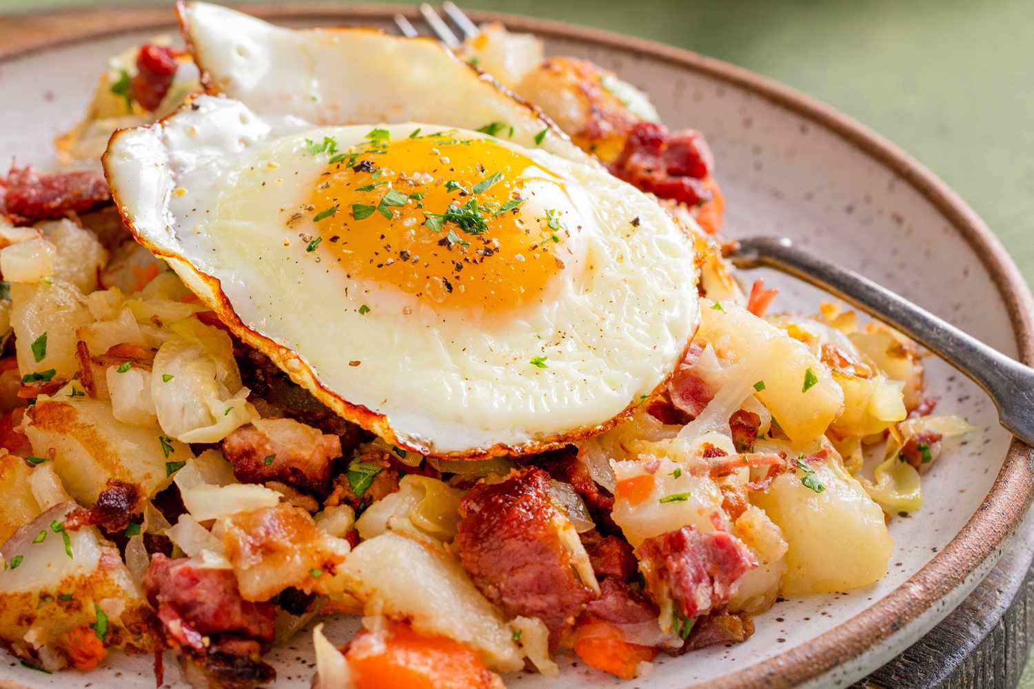 plate of breakfast hash with a fried egg on top