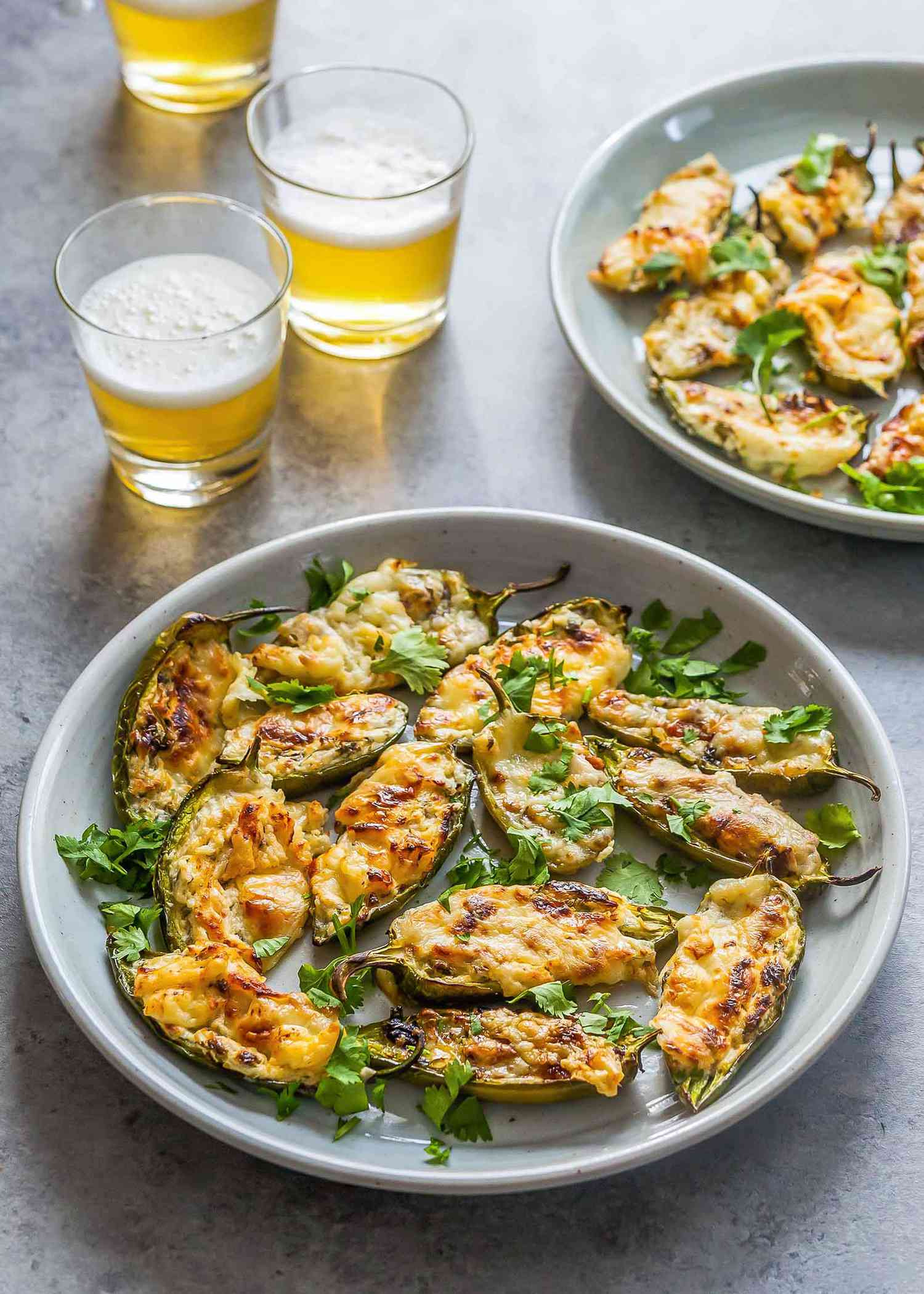 Baked stuffed jalapeños on two white plates