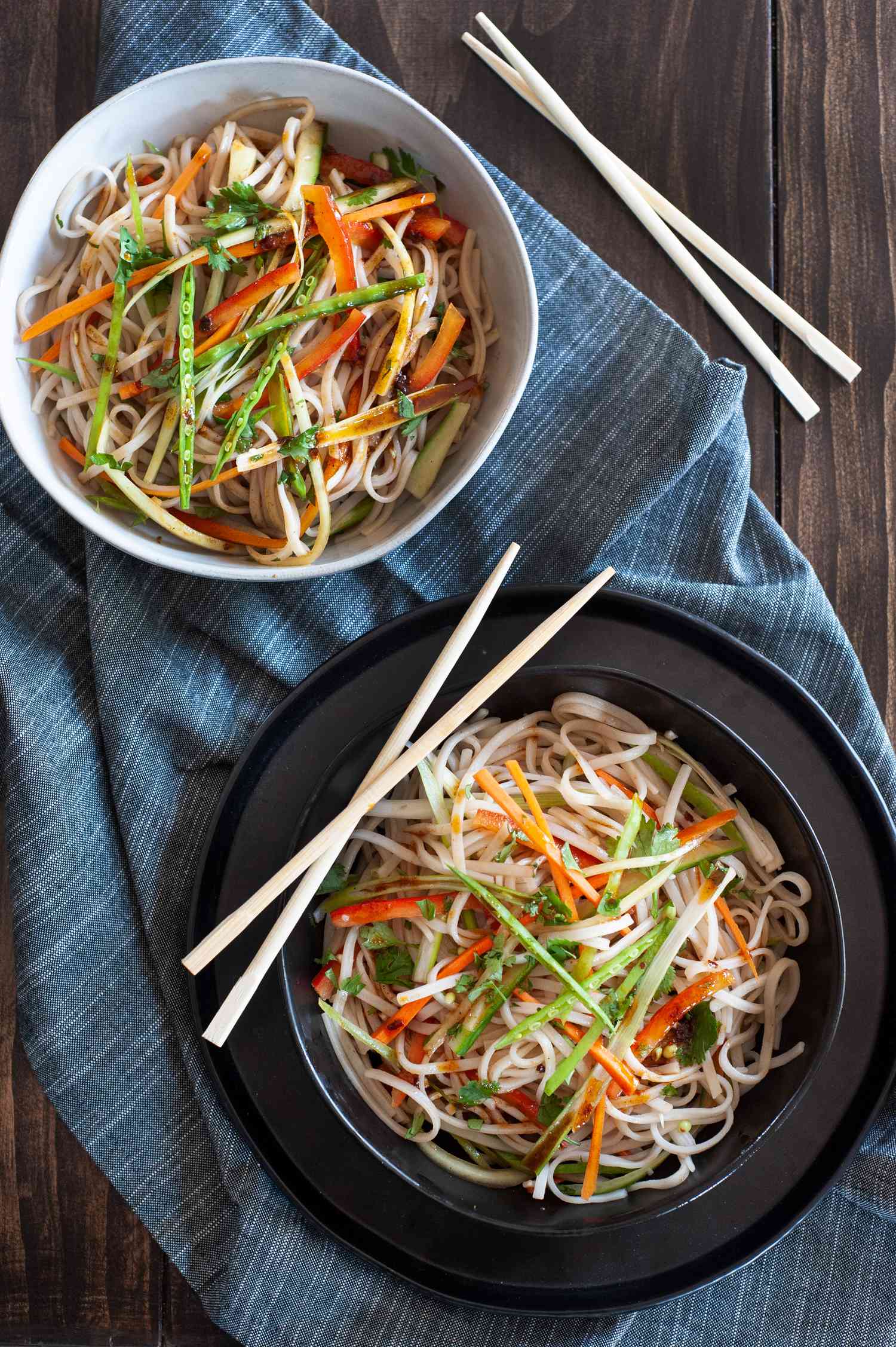 Rice noodle salad with sesame dressing seen overhead in two bowls with chopsticks set next to them.