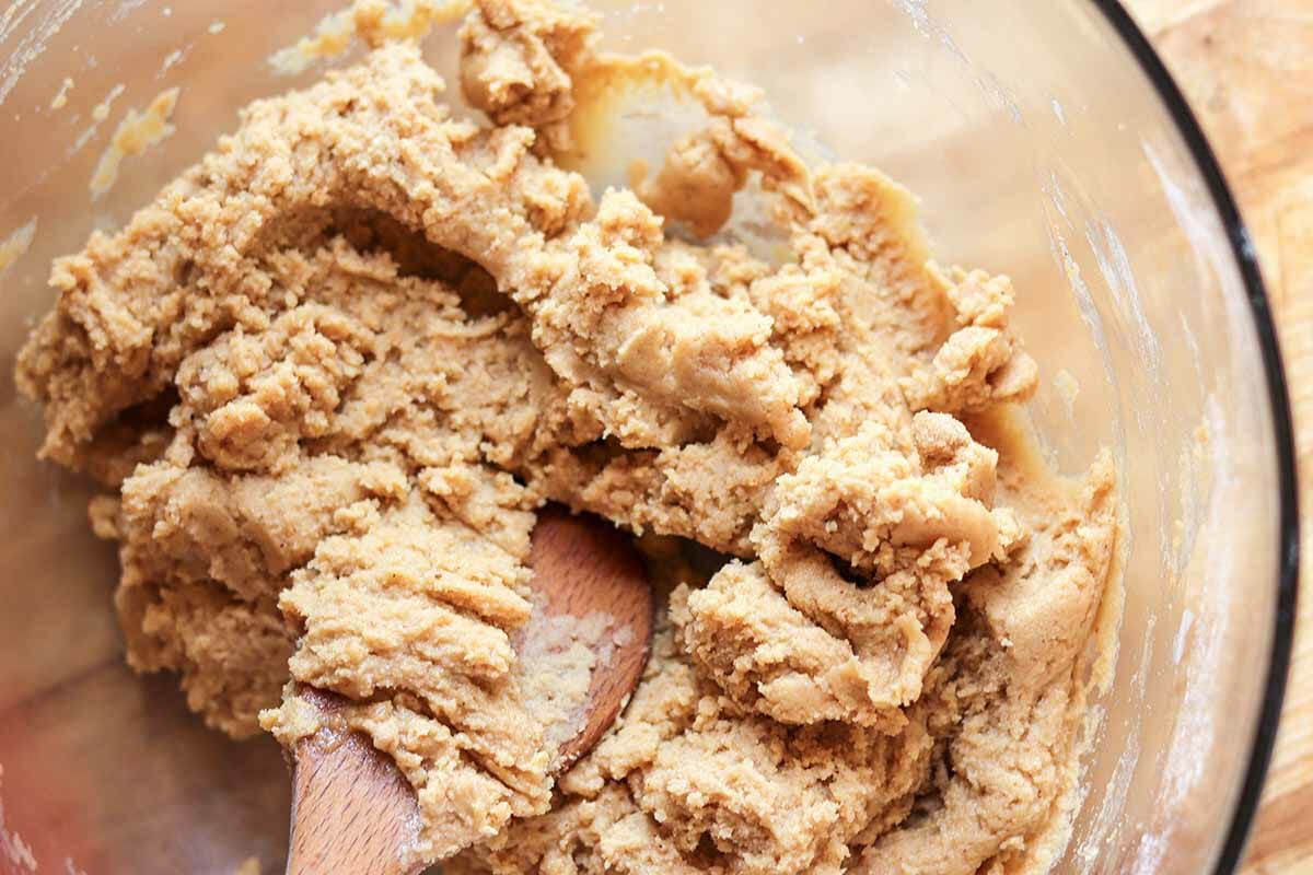 Dough mixed with a wooden spoon to make Hershey kiss cookies.