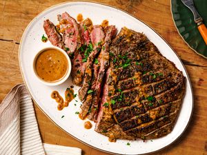 Overhead view of easy steak au poivre on a platter on a wooden tabletop