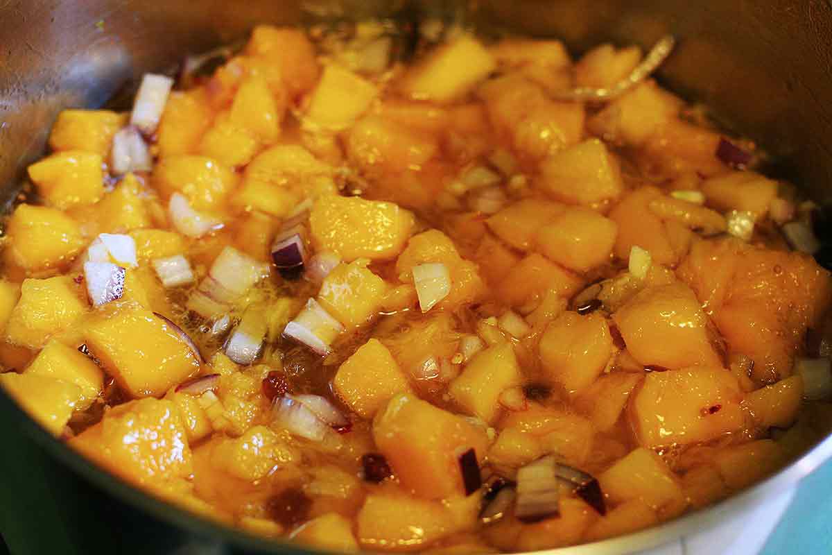 A pan of mango chunks and seasonings ready to cook into mango chutney