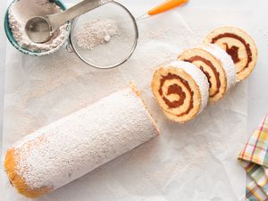 Roll Cake with Guava Jelly topped with powdered sugar and cut into a few slices.