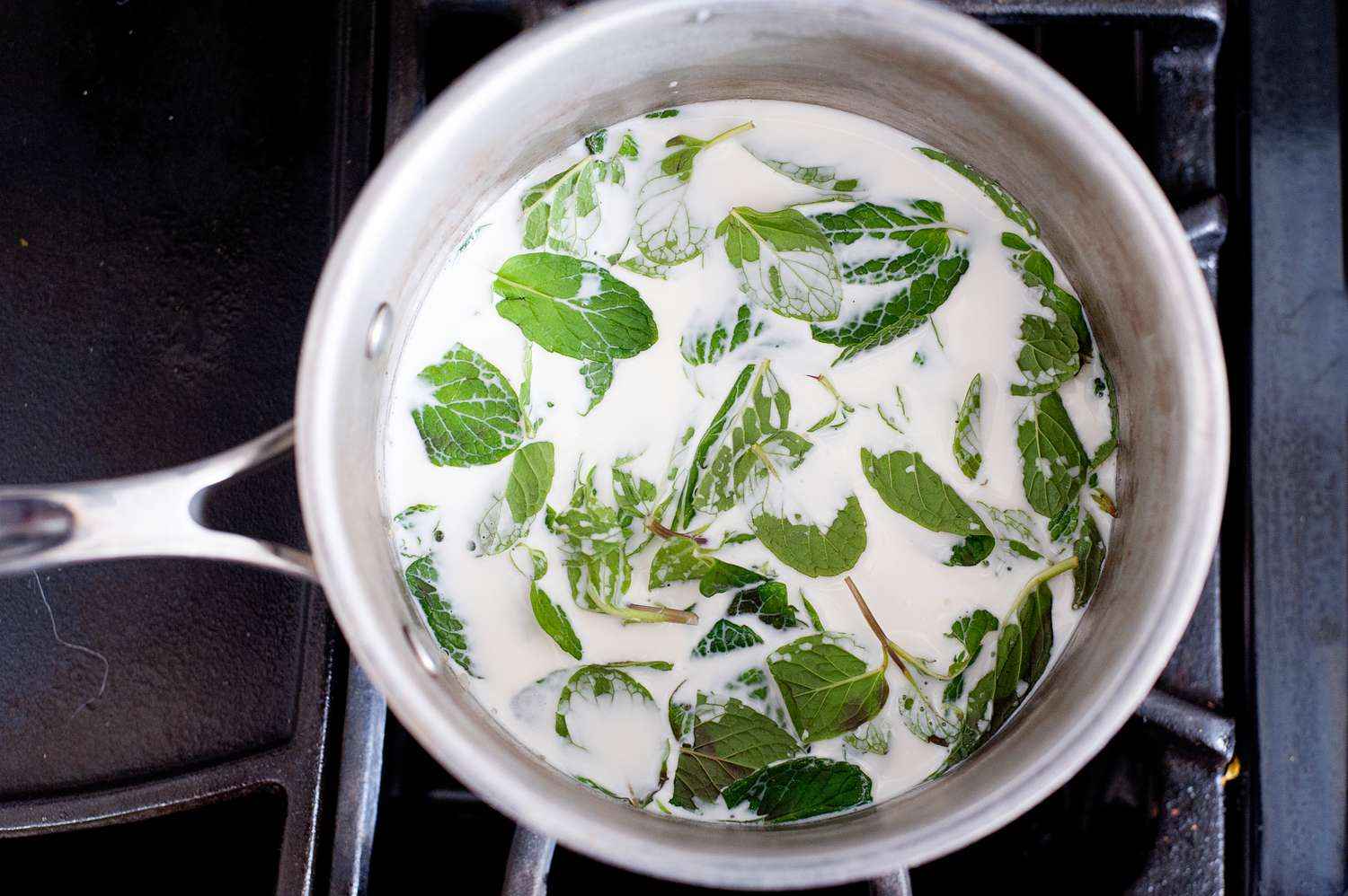 Steeping mint leaves in cream to make chocolate chip ice cream.