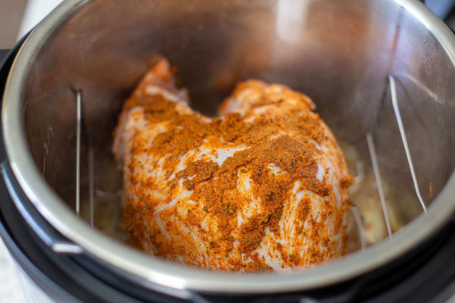 A turkey breast in an Instant Pot on a wire rack.