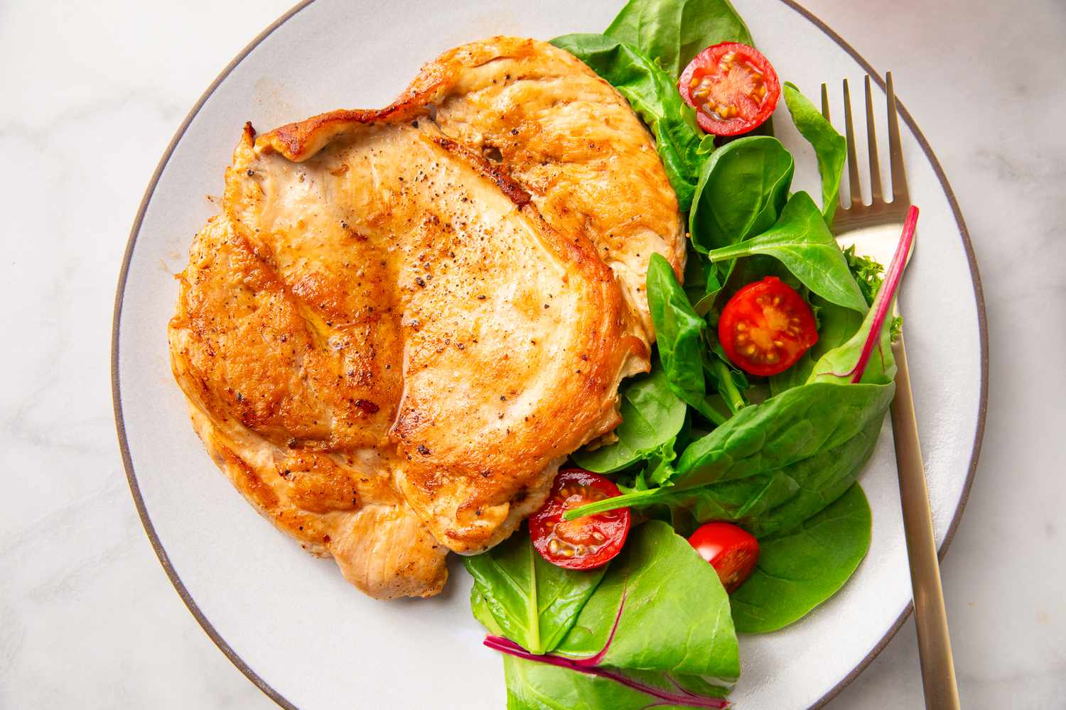 Chicken breast served with salad on a plate