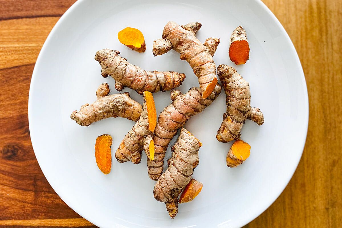 Fresh turmeric on a plate to make Homemade Jamu.