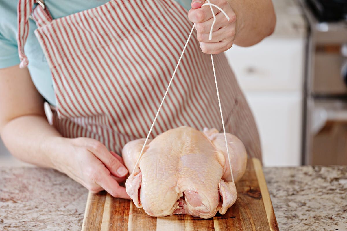 Trussing a chicken for roasting slide the twine underneath