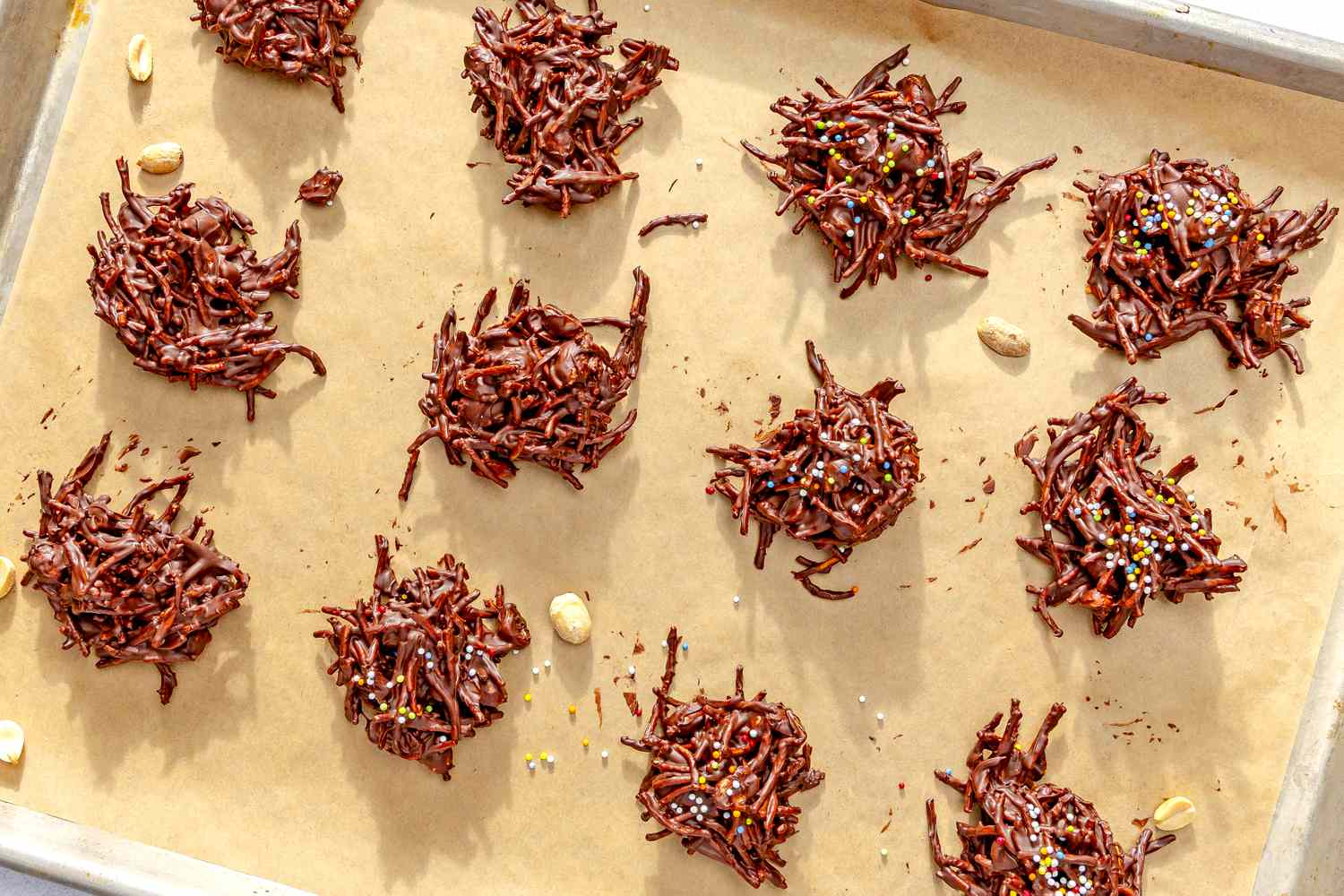 Tray of chocolate chow mein cookies with sprinkles on parchment paper
